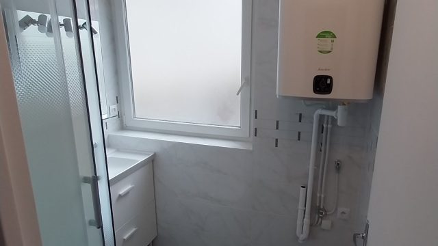 Salle de bain refaite avec cabine de douche, meuble vasque et chauffe-eau neuf